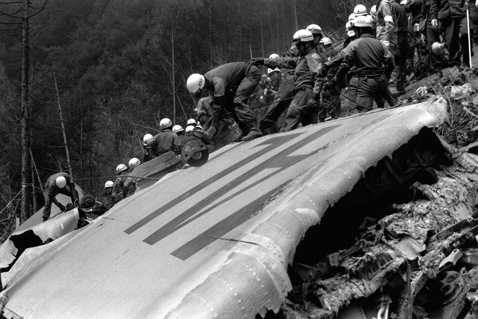 Police officers dismantle the primary wing at the crash site at the ridge of Mount Osutaka