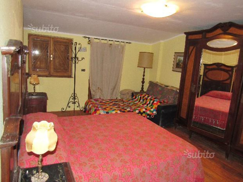 a bedroom with two beds and a lamp with the word subito on the bottom