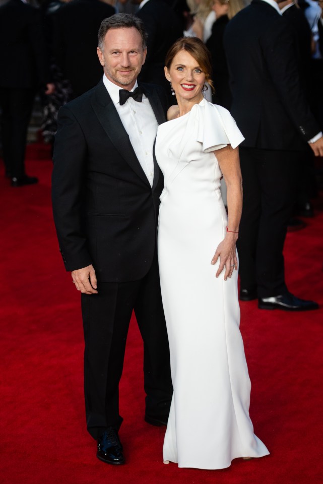 a man in a tuxedo and a woman in a white dress pose on a red carpet