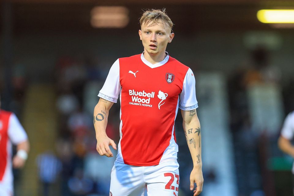 a soccer player wearing a red and white bluebell wood jersey