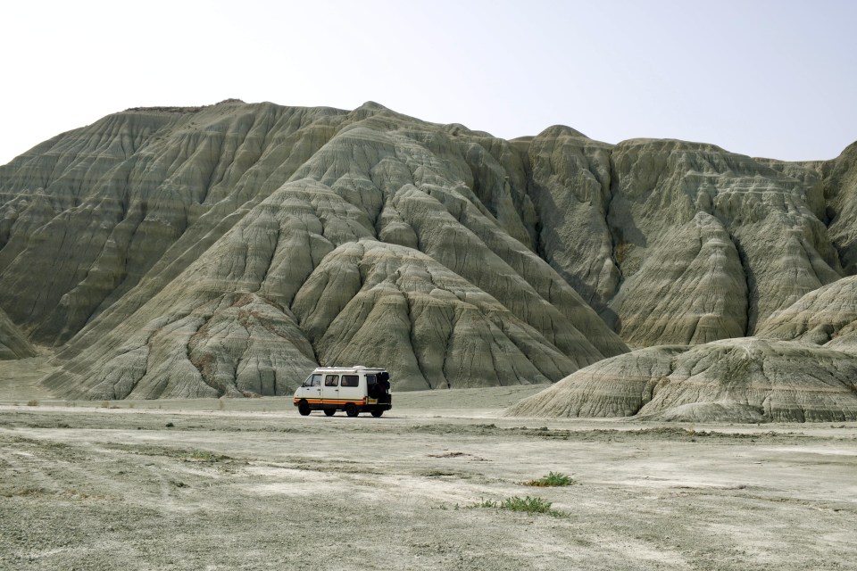 a white van is parked in front of a mountain