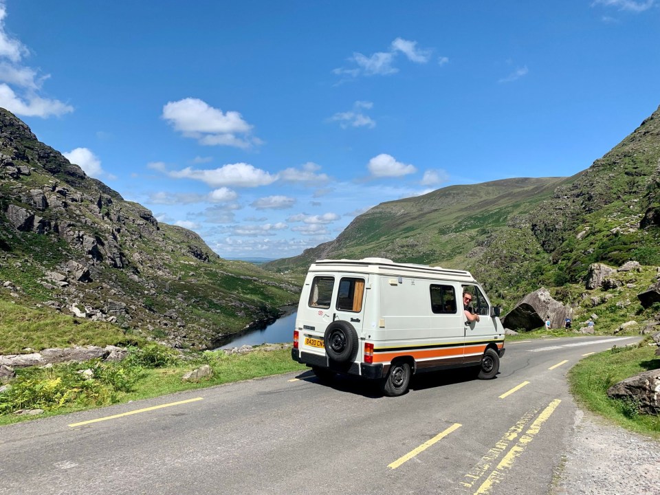 a white van is driving down a road with a license plate that says ' rv ' on it