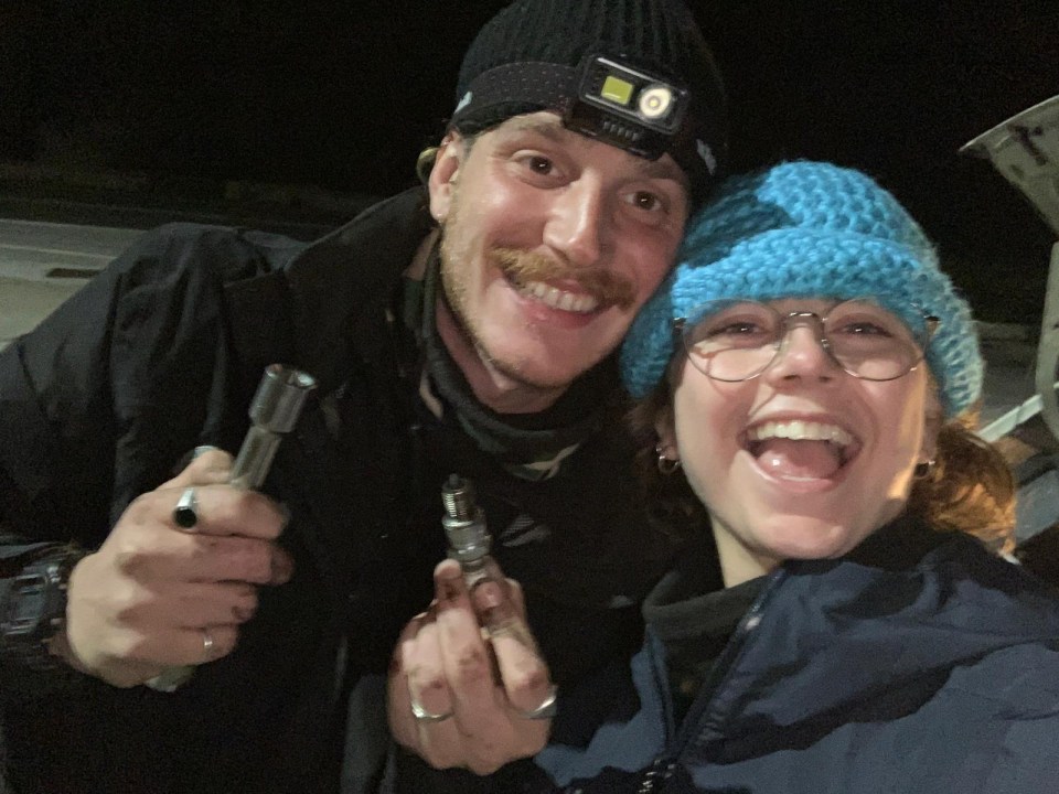 a man wearing a nite ize headlamp smiles next to a woman