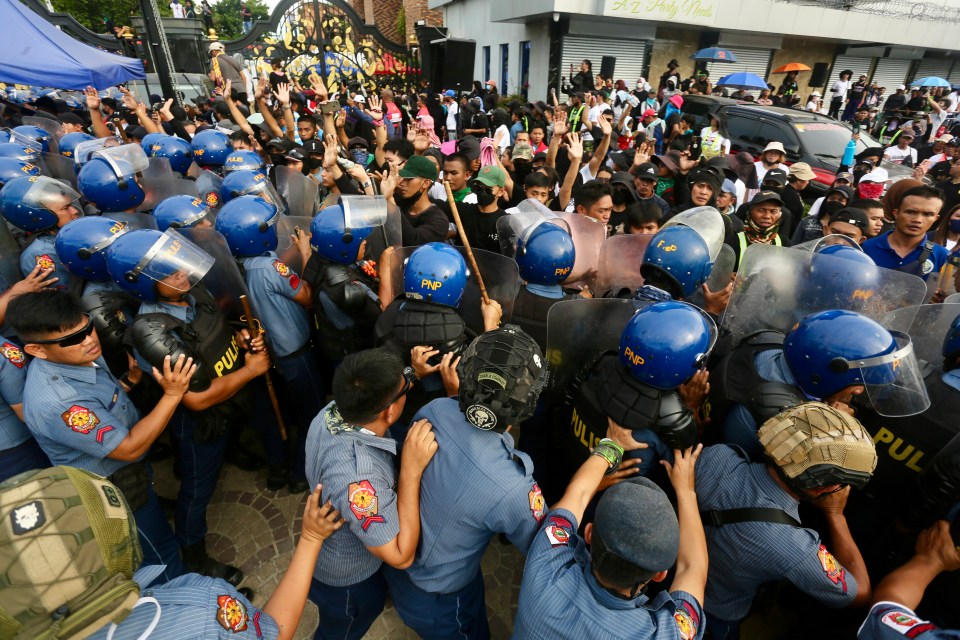 Anti-riot cops are clashing with diehard cult followers in the Philippines over the arrest of a wanted preacher