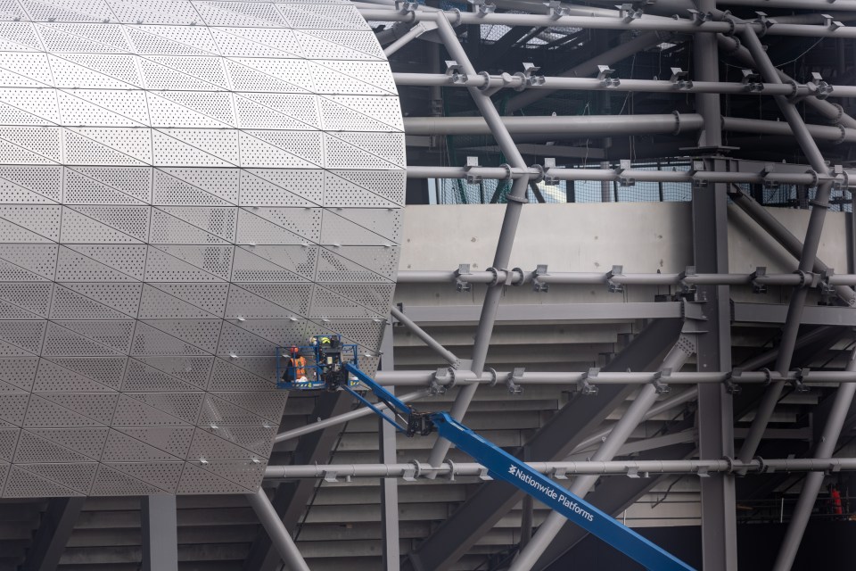 Construction workers put on cladding earlier this year