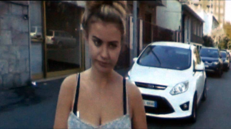 a woman stands in front of a white ford car