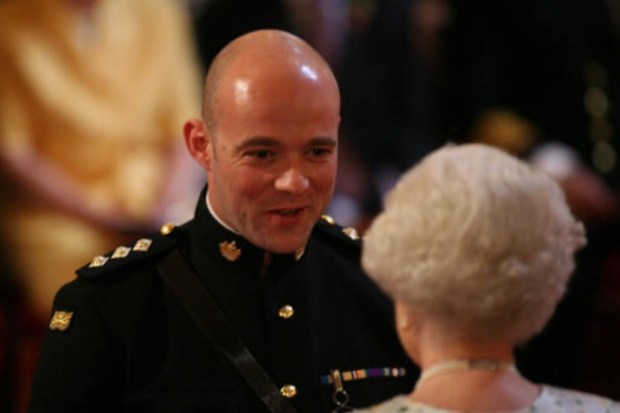 a man in a military uniform talks to a woman in a white dress