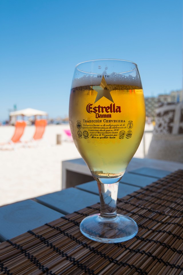 a glass of estrella damm sits on a table