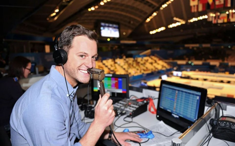 a man wearing headphones is smiling while holding a microphone