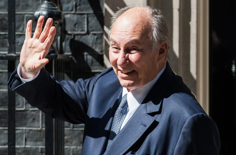 a man in a suit and tie is waving his hand