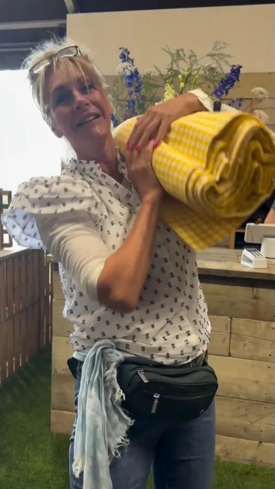 a woman in a white shirt is carrying a yellow blanket