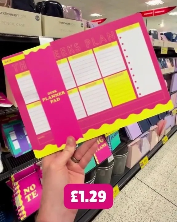 a person is holding a weekly planner pad that costs 1.29