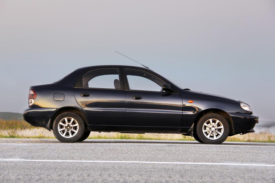 a black car is parked on the side of the road