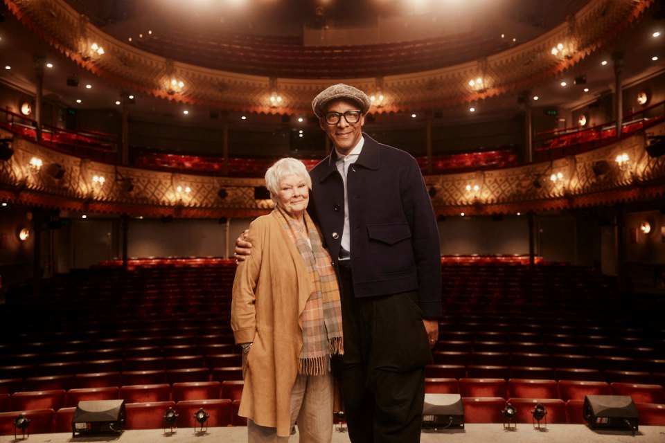 a man and woman are posing for a picture in an auditorium