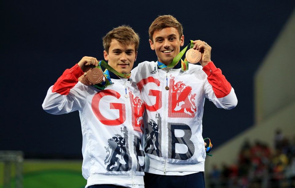 two athletes are posing for a picture and one has the word gbb on his jacket