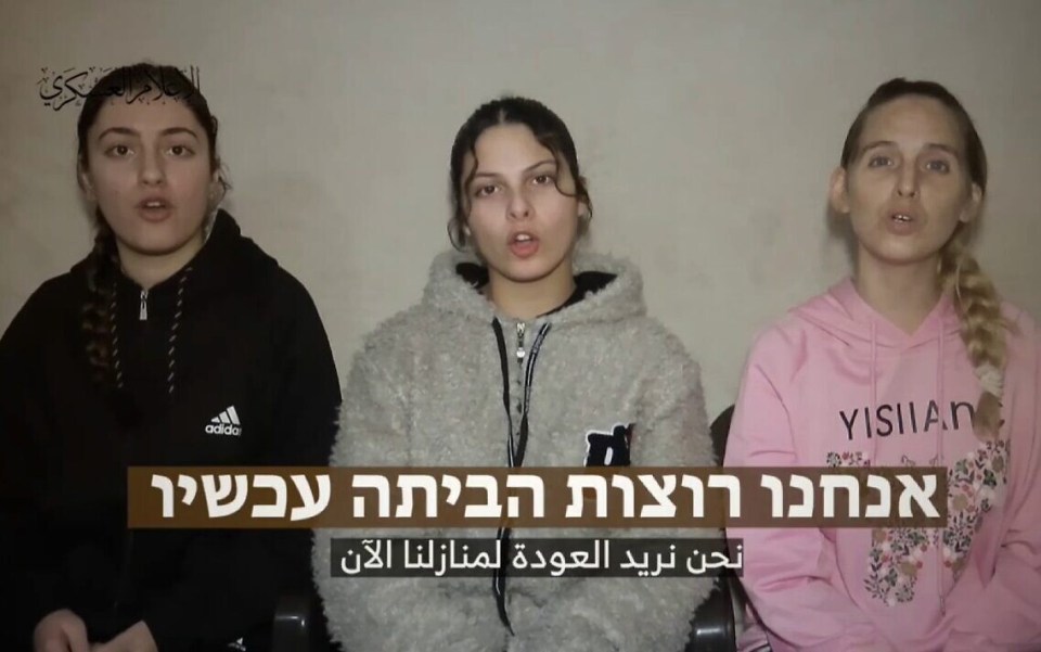 three girls are sitting in front of a sign that says yishian