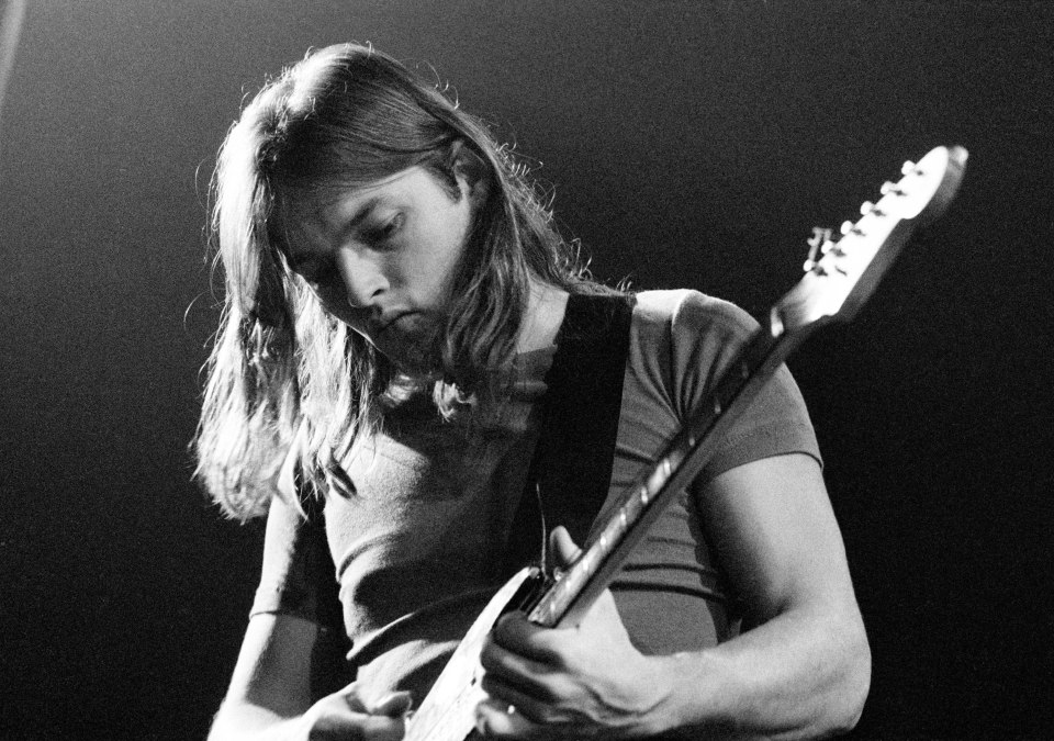 a man with long hair is playing an electric guitar