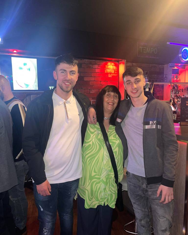 two men and a woman pose for a picture in front of a sign that says tempo