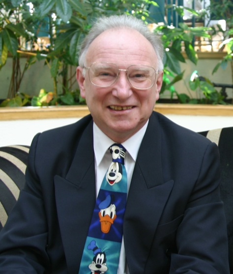 a man wearing a tie with mickey mouse and goofy on it