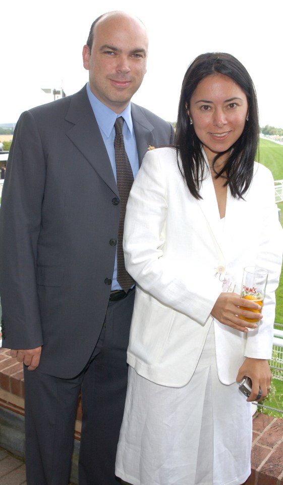 a man in a suit and tie stands next to a woman in a white jacket