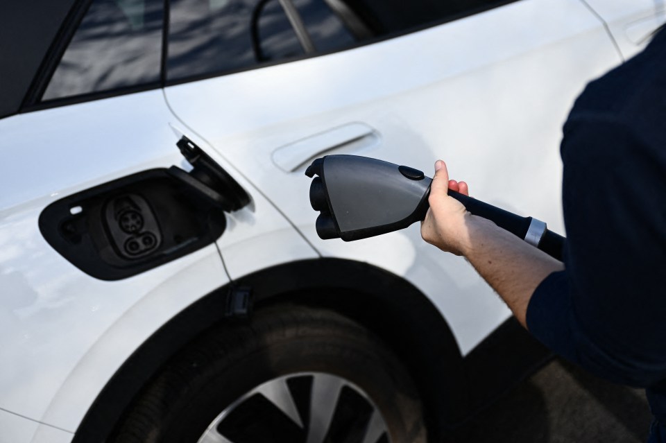 a person is charging an electric car with a charger