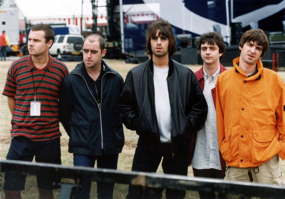 a group of men standing next to each other with one wearing an orange jacket