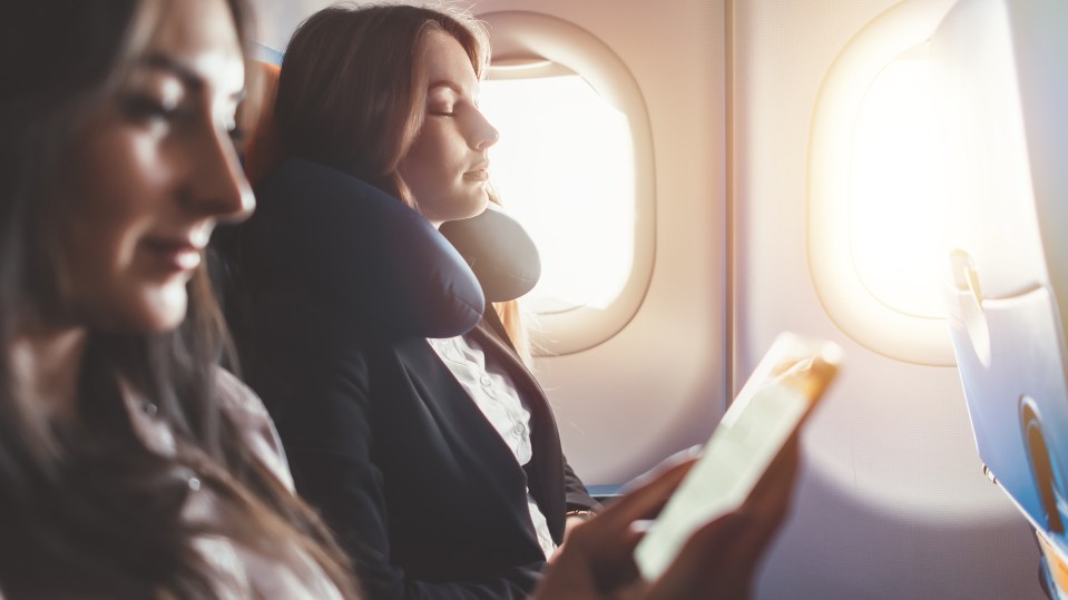 Two females going on business trip by plane. A woman reading an e-book on a smartphone.