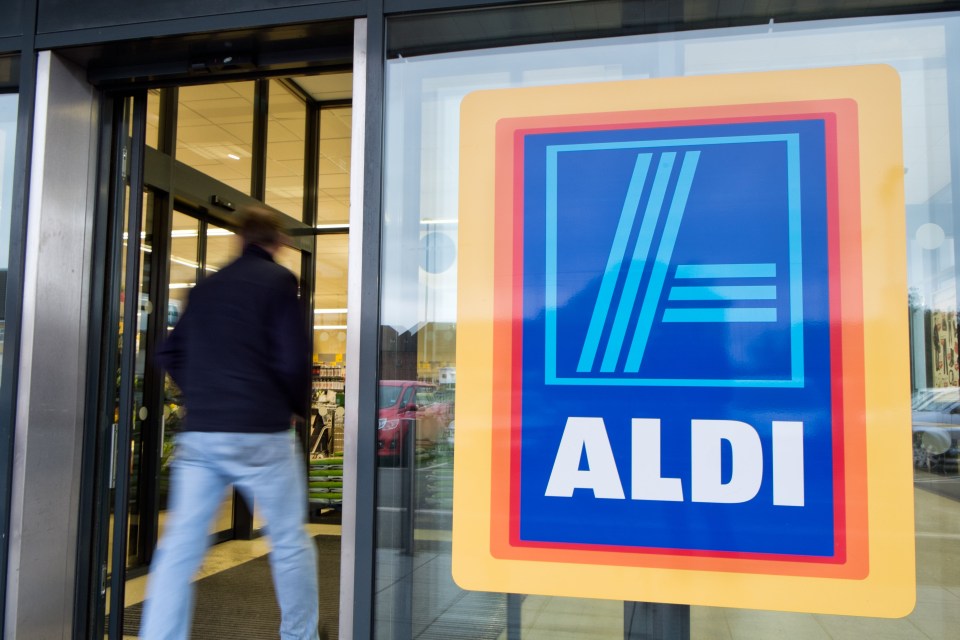 a man is walking into an aldi store