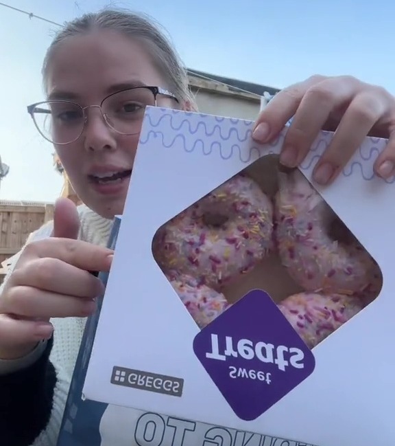 a girl is holding a box of donuts with the words too good to go bag below her