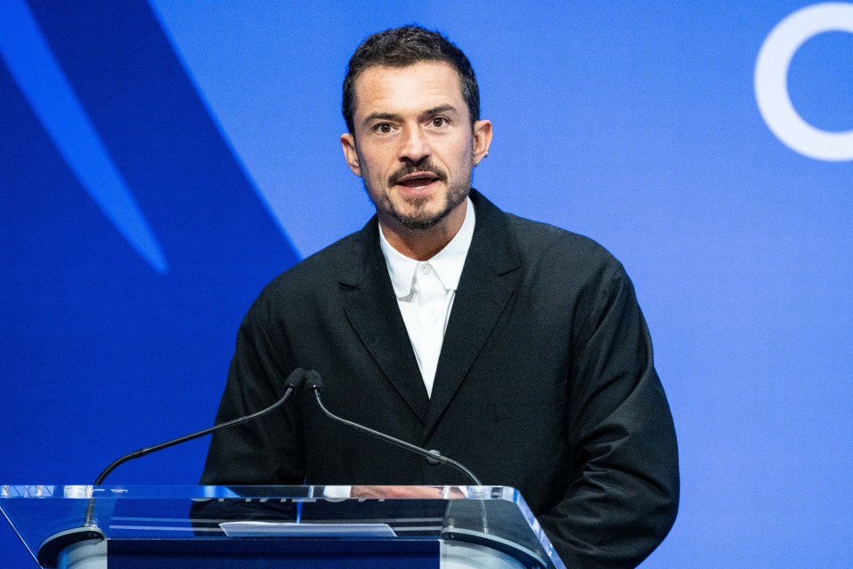 a man stands at a podium with two microphones in front of him