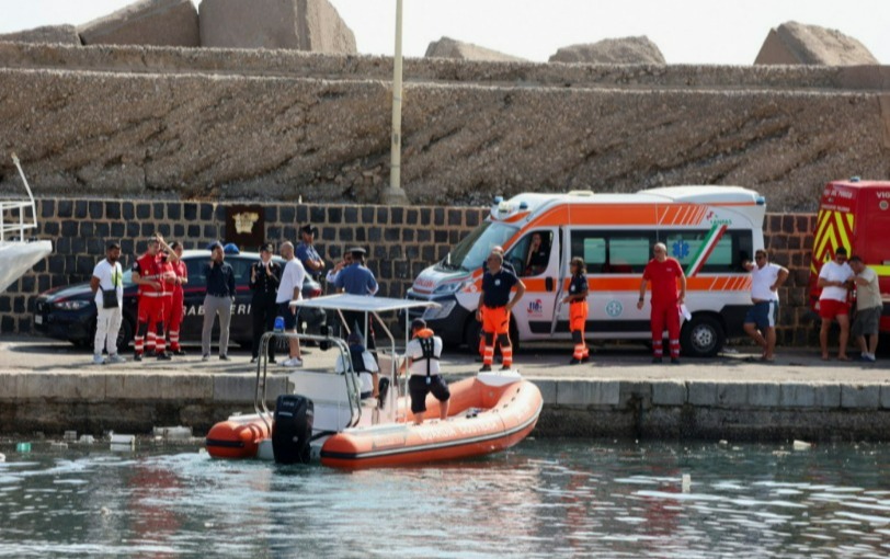 a helicopter is flying over a body of water next to an ambulance