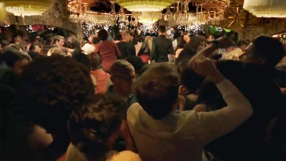 a crowd of people are dancing in a room with bbc written on the bottom