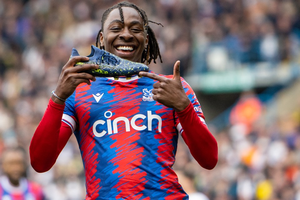 a soccer player wearing a cinch jersey holds up a shoe