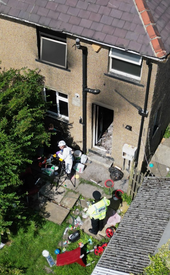 an aerial view of a police officer in front of a house