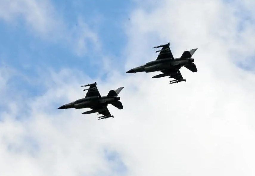 Two F-16s fly side-by-side looking menacing