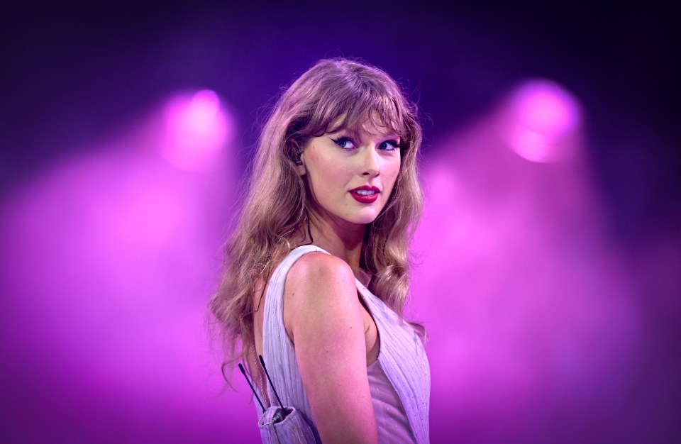 a woman in a white dress is standing in front of purple lights