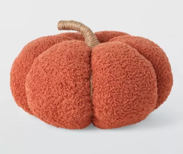 a stuffed pumpkin with a rope stem on a white background