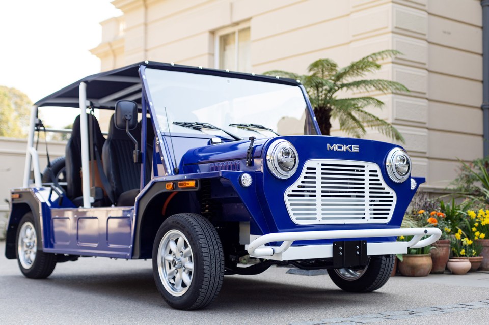 a blue moke vehicle is parked in front of a building