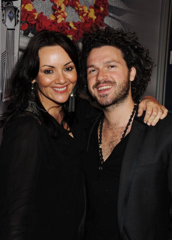 a man and a woman are posing for a picture and the woman is smiling