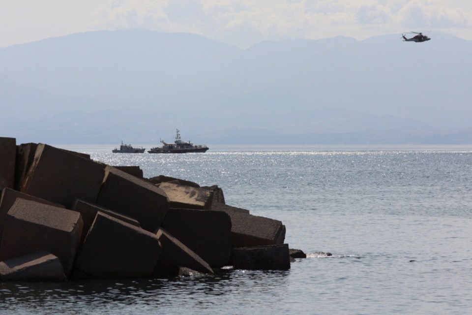 a helicopter is flying over a body of water