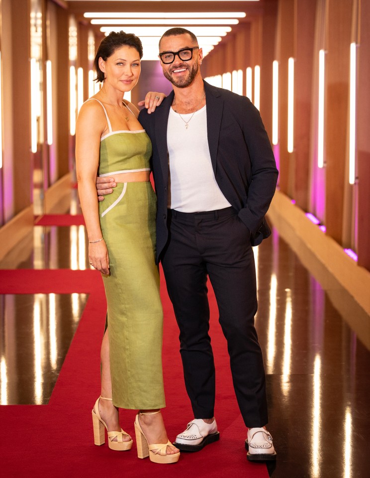 a man and a woman pose for a picture on a red carpet