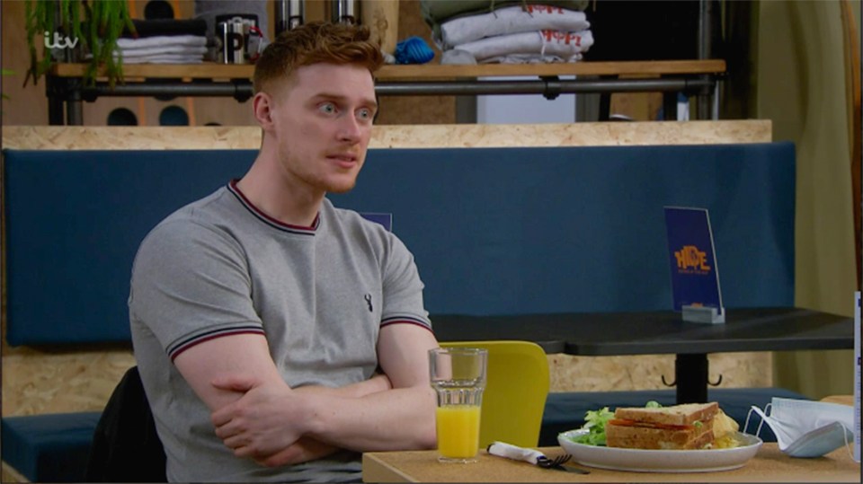 a man sits at a table with a plate of food and a sign that says itv