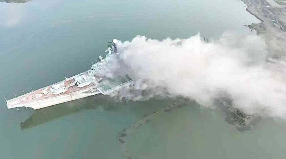 an aerial view of a large ship in the water with smoke coming out of it