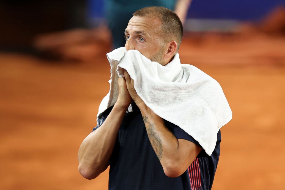 a man wipes his face with a white towel