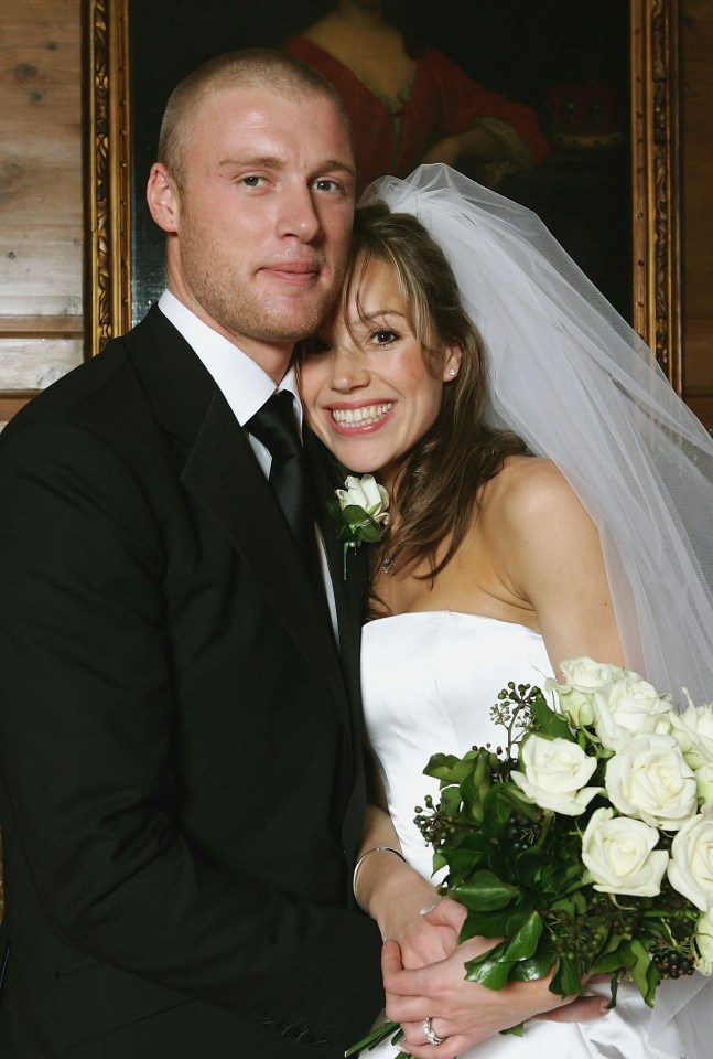 a bride and groom pose for a picture in front of a painting