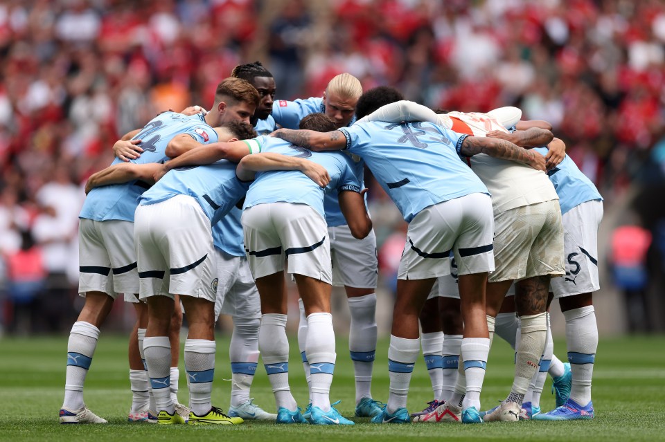 a group of soccer players huddle together with one wearing the number 5