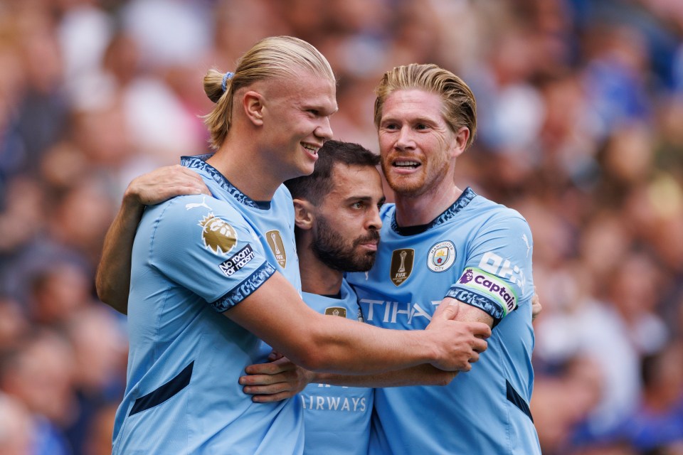 three soccer players are hugging each other and one of their shirts says airways