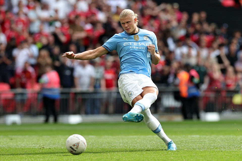 a man in a blue etihad airways jersey kicking a soccer ball