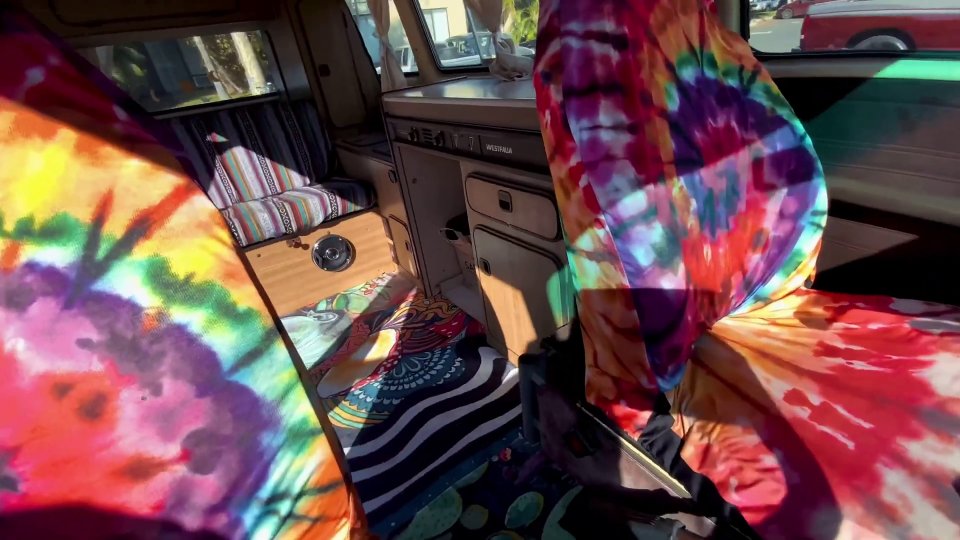 the inside of a camper van with tie dye seat covers