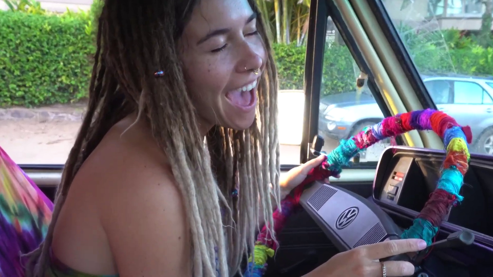 a woman with dreadlocks is sitting in a vw van